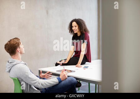 Männliche und weibliche Jungdesigner mit Diskussion im Design-studio Stockfoto