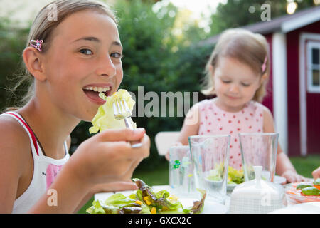 Porträt eines Mädchens essen Salat im Garten, Bayern, Deutschland Stockfoto