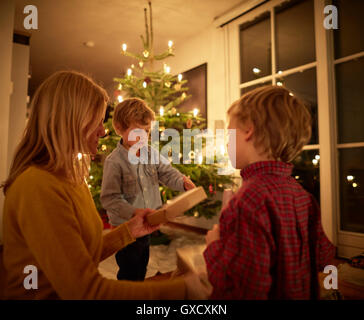 Mutter und Söhne zu Weihnachten zu Hause sitzen, Austausch von Geschenken Stockfoto