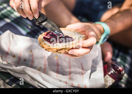 Nahaufnahme von Frau Verbreitung Marmelade auf bestreute Brötchen, Meran, Südtirol, Italien Stockfoto