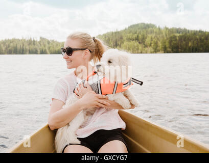Frau mit Coton de Tulear Hund im Boot, Orivesi, Finnland Stockfoto