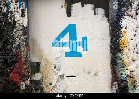 Nummer 4 Tür und Farbe bedeckte Wand in Werft Maler Stockfoto