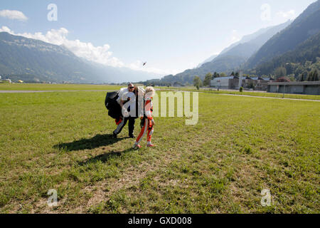 Tandem Sky Taucher zu Fuß im Feld nach der Landung, Interlaken, Bern, Schweiz Stockfoto