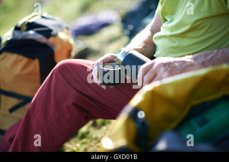 Blick auf Wanderer Gießen Tee aus der Flasche abgeschnitten Stockfoto