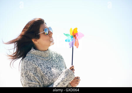 Frau mit Sonnenbrille mit Windrad Stockfoto