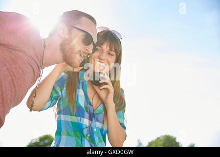 Junges Paar im Freien, anhören von Musik über Kopfhörer Stockfoto