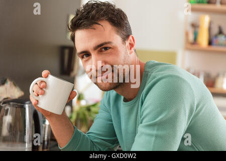 Porträt des Mannes halten Kaffeetasse Blick auf die Kamera zu Lächeln Stockfoto