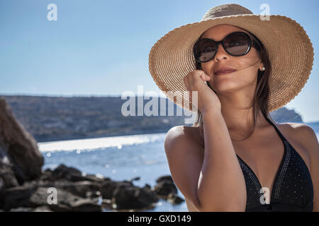 Schöne junge Frau trägt Sonnenhut auf Strand, Villasimius, Sardinien, Italien Stockfoto