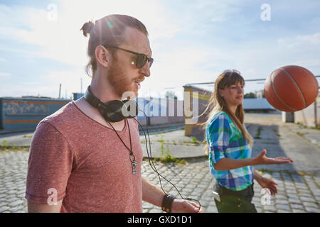 Junges Paar im Freien, werfen basketball Stockfoto