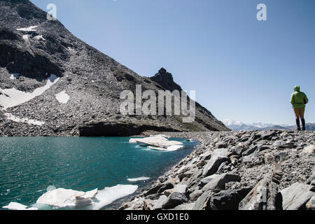 Mann steht neben Morasco See, Morasco, Val Formazza, Piemont, Italien Stockfoto