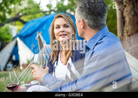 Älteres Paar im Chat auf der Hängematte im Garten-party Stockfoto