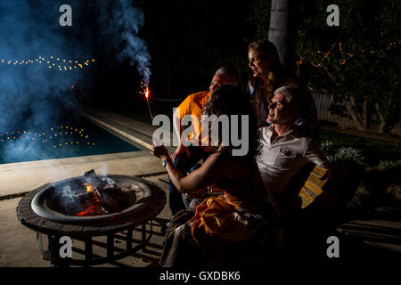 Reife Erwachsene Paare beobachten Wunderkerze Terrasse Feuer in der Nacht Stockfoto