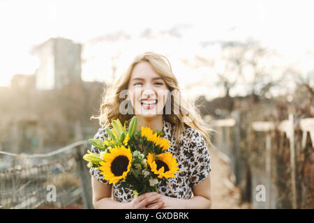 Porträt der jungen Frau mit Sonnenblumen, Lächeln Stockfoto