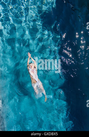 Draufsicht der Frau auf Rücken im Pool schwimmen Stockfoto