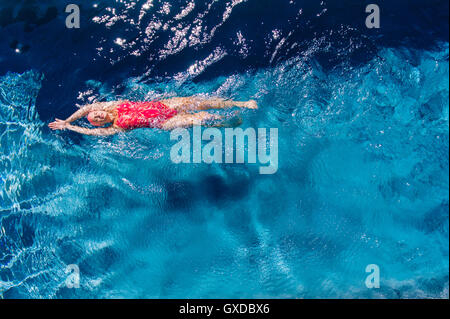 Draufsicht der Frau auf Rücken im Pool schwimmen Stockfoto