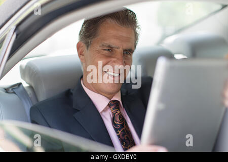 Reife Geschäftsmann hinter dem Auto, mit digital-Tablette Stockfoto