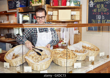 Männliche Arbeiter in Bäckerei, wobei frische Ware aus Korb Stockfoto