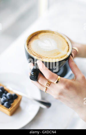 Weibes Hände halten schaumig Kaffee Stockfoto