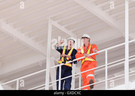 Ingenieure in der Diskussion auf Bohrinsel Stockfoto