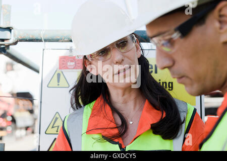 Ingenieure in der Diskussion auf Bohrinsel Stockfoto