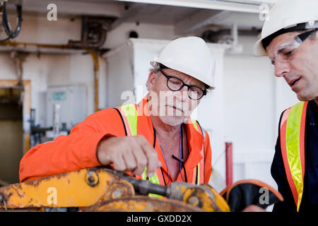 Ingenieure in der Diskussion auf Bohrinsel Stockfoto