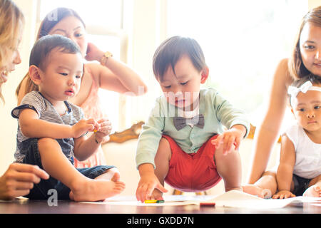 Baby Junge Abholung Kreide auf Esstisch Stockfoto