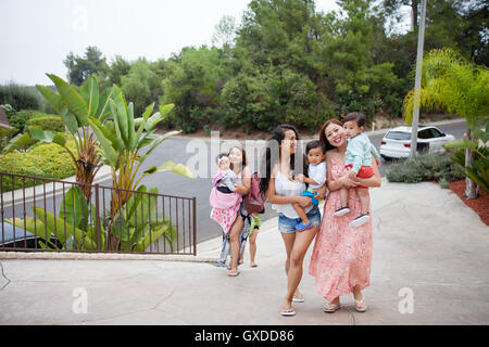 Frauen, die kleine Tochter und Söhne bewegen, Auffahrt, Malibu, Kalifornien, USA Stockfoto