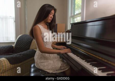 Teenager-Mädchen spielen Klavier im Speisesaal sitzen Stockfoto