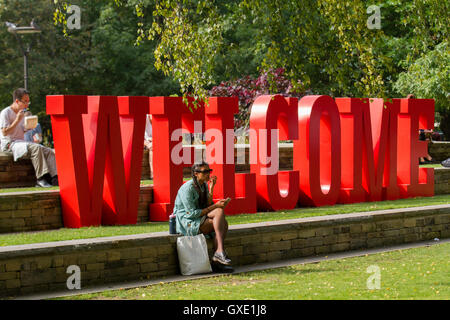 Red Willkommen Zeichen in der Sonne für ausländische Studenten; Ankunft an der Metropolitan University Garten von Manchester, in frischer Woche, September, 2016, UK Stockfoto