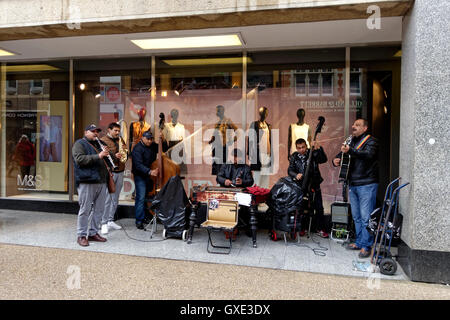 Eine Straße Straßenmusik Band außerhalb des Marks & Spencer store in der Queens Street, Oxford, Vereinigtes Königreich. Stockfoto