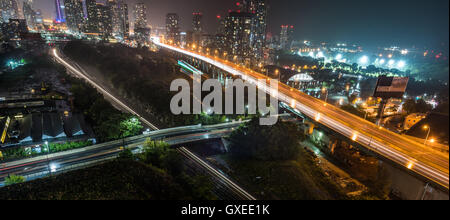 Glow helle Streifen von u-Bahn Zug neben Gardiner Expressway in einer heißen & schwülen Sommernacht in Toronto, Kanada am See. Stockfoto