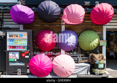 Japan, Izushi. Otemae-dori, touristischen Einkaufsstraße. Souvenir einer Farbe in verschiedenen Farben, Schirme angezeigt draußen auf der Vorderseite des Shop. Stockfoto