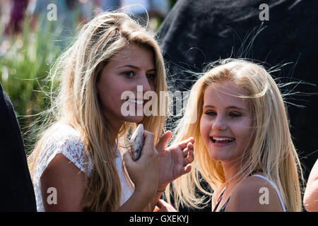 Zwei blonde Mädchen, 13-14 Jahre alt, beide drehten ihre Köpfe zu Gesicht beim Lachen, Sonnenlicht, ihr Haar verfängt. Kopf schoss. Kein Auge - Kontakt. Stockfoto