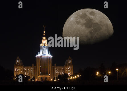 Fantastische Stadtbild: Nachtansicht auf der Moskauer staatlichen Universität Gebäude mit Straßen, Lichter und riesigen anfallenden Mond am dunklen Himmel Stockfoto