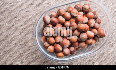 Nüssen in der Schale auf einem hölzernen Brett closeup Stockfoto