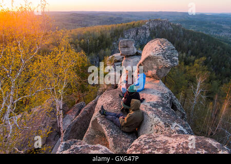 Kaukasische Freunde sitzen auf Berg Felsen bewundern Sie malerische Aussicht Stockfoto