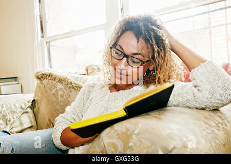 Lächelnd Mischlinge Frau Lesebuch Stockfoto