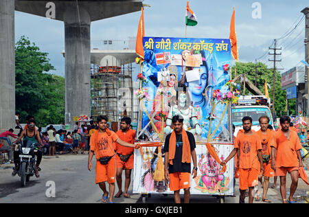 Kavad Yatra ist jährliche Wallfahrt der Anhänger von Shiva, Personenbeförderung überdachte Wasser-Töpfe in Kānvars über ihre Schultern geschlungen Stockfoto