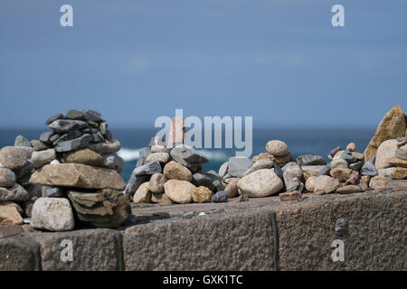 Handgemachte Steinhaufen bekannt als Cairns, entlang einer Küstenregion in Jersey, Kanalinseln Stockfoto