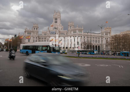 Verkehr, hetzen, vorbei an Plaza de Cibeles in Madrid unter einem marodierenden Himmel, Spanien, April Stockfoto