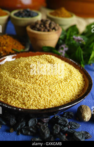 Bio Couscous und verschiedenen Gewürzen in traditionellen östlichen Tonschalen, Zutaten für Salat Stockfoto