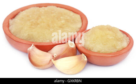 Zerdrückten Knoblauch mit Hülsen auf weißem Hintergrund Stockfoto