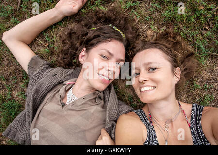 glückliche junge Frauen liegen auf dem Boden und nehmen selfie Stockfoto