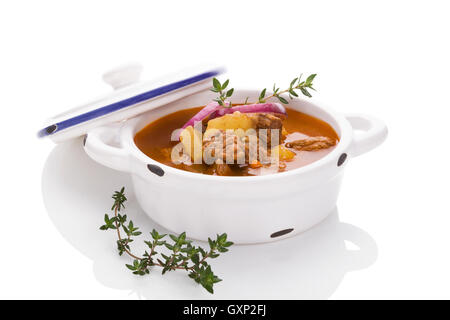 Leckere Gulaschsuppe im weißen Topf auf weißem Hintergrund. Kulinarischen traditionelle Gulasch essen. Stockfoto