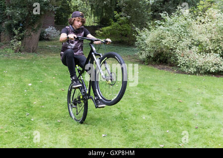 Teenager machen einen Wheelie auf seinem Fahrrad, Berkshire UK Stockfoto