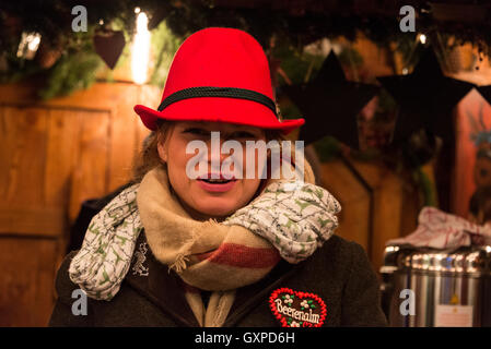 Mitglied der Rechtsanwaltskammer Personal mit bayerischen gefiederten hüten mit Glühwein in einer der vielen Holzhütten in München Weihnac Stockfoto