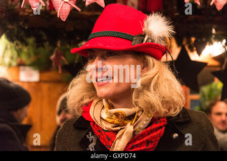 Mitglied der Rechtsanwaltskammer Personal mit bayerischen gefiederten hüten mit Glühwein in einer der vielen Holzhütten in München Weihnac Stockfoto