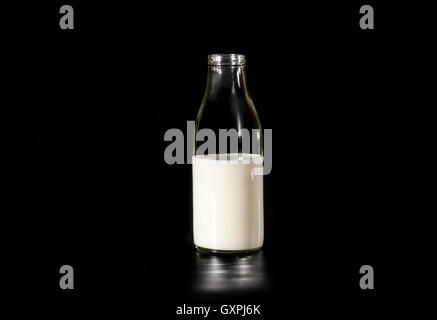 Kuhmilch in einer Glasflasche auf dunklem Hintergrund Stockfoto