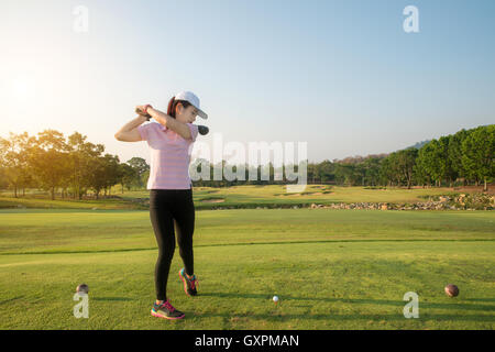 Asiatische Frau Golf hit weitläufigen Golfplatz im Sommer. Golf-Sport-Konzept. Stockfoto