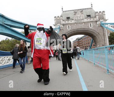 Teilnehmer in Fancy dress crossing Tower Bridge, London, während The Great Gorilla Run. Stockfoto